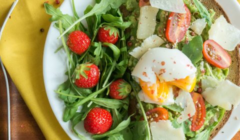 Une tartine avocat, oeuf mollet et sa salade roquette fraises.